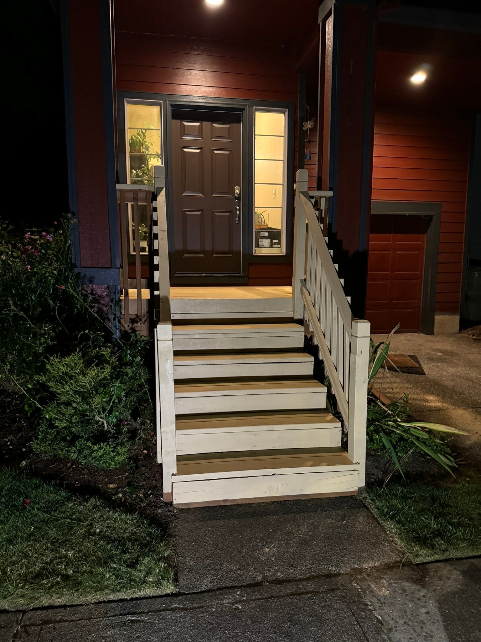 A red house with white stairs leading up to the front door.