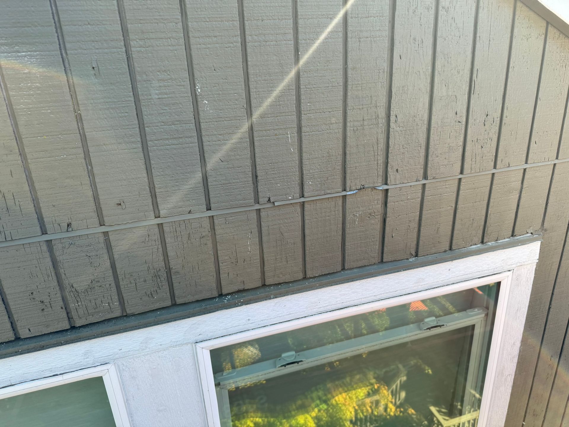 An aerial view of a house with a window and siding.