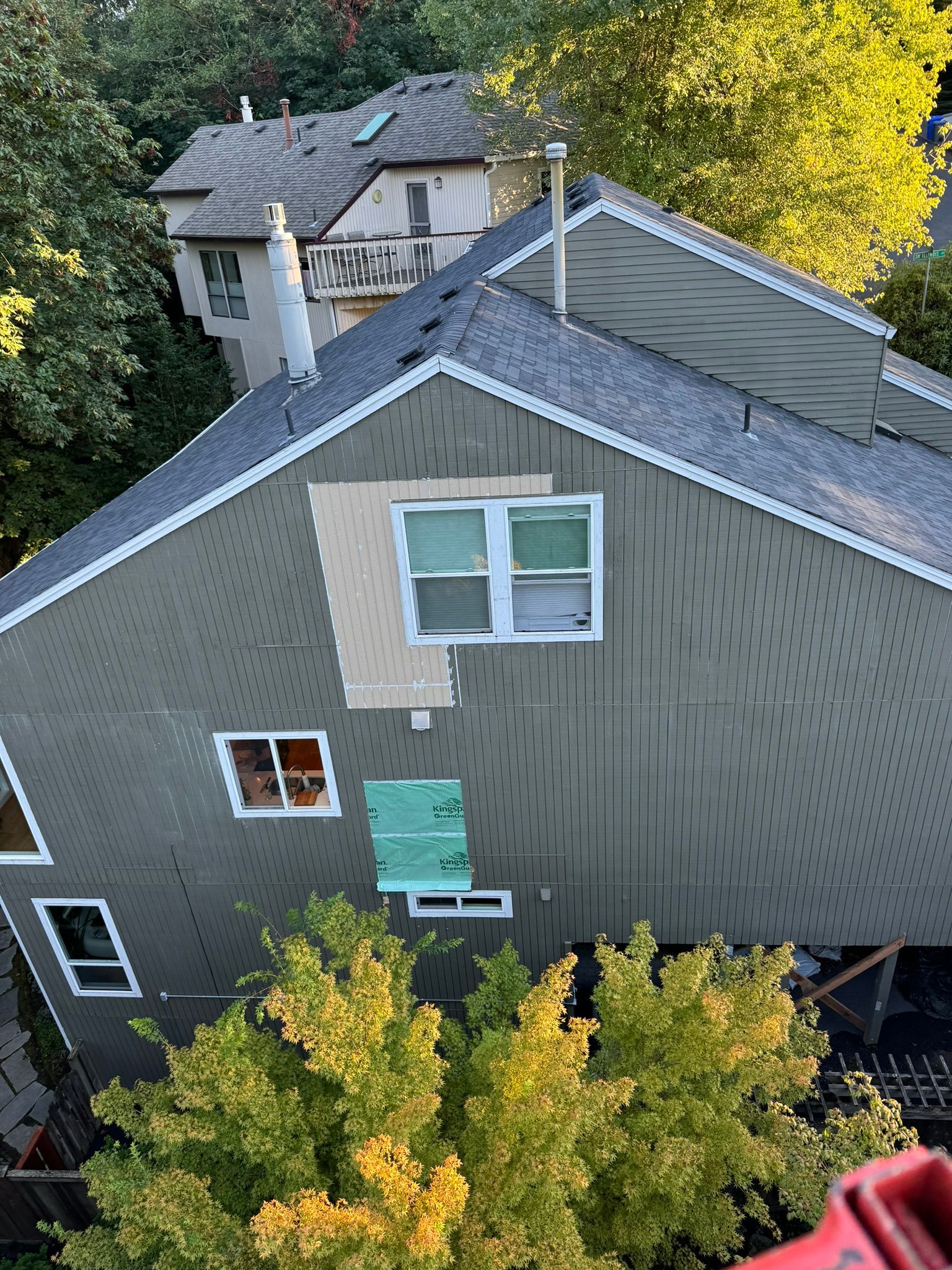 An aerial view of a house with a roof that is being repaired.