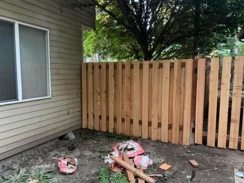 A wooden fence is being built in front of a house.