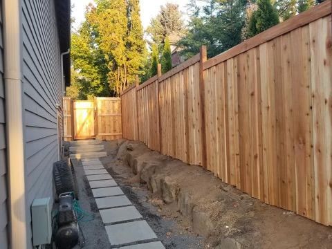 A wooden fence along the side of a house