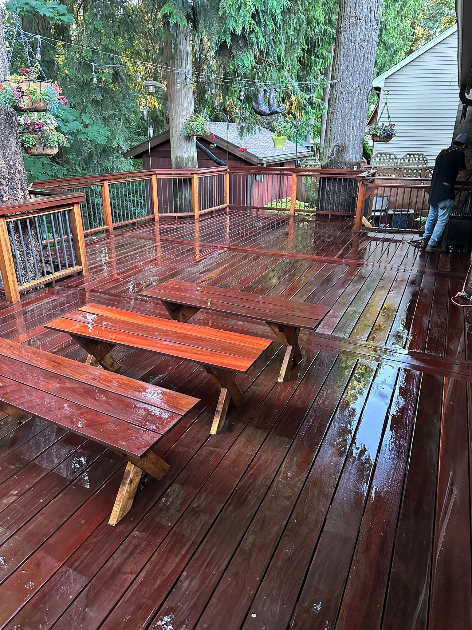 A wooden deck with tables and benches in the rain.