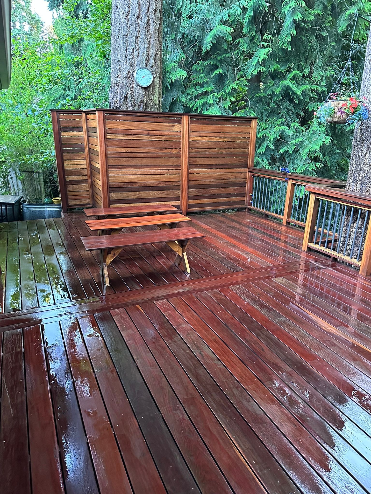 A wooden deck with a bench and a hot tub on it.