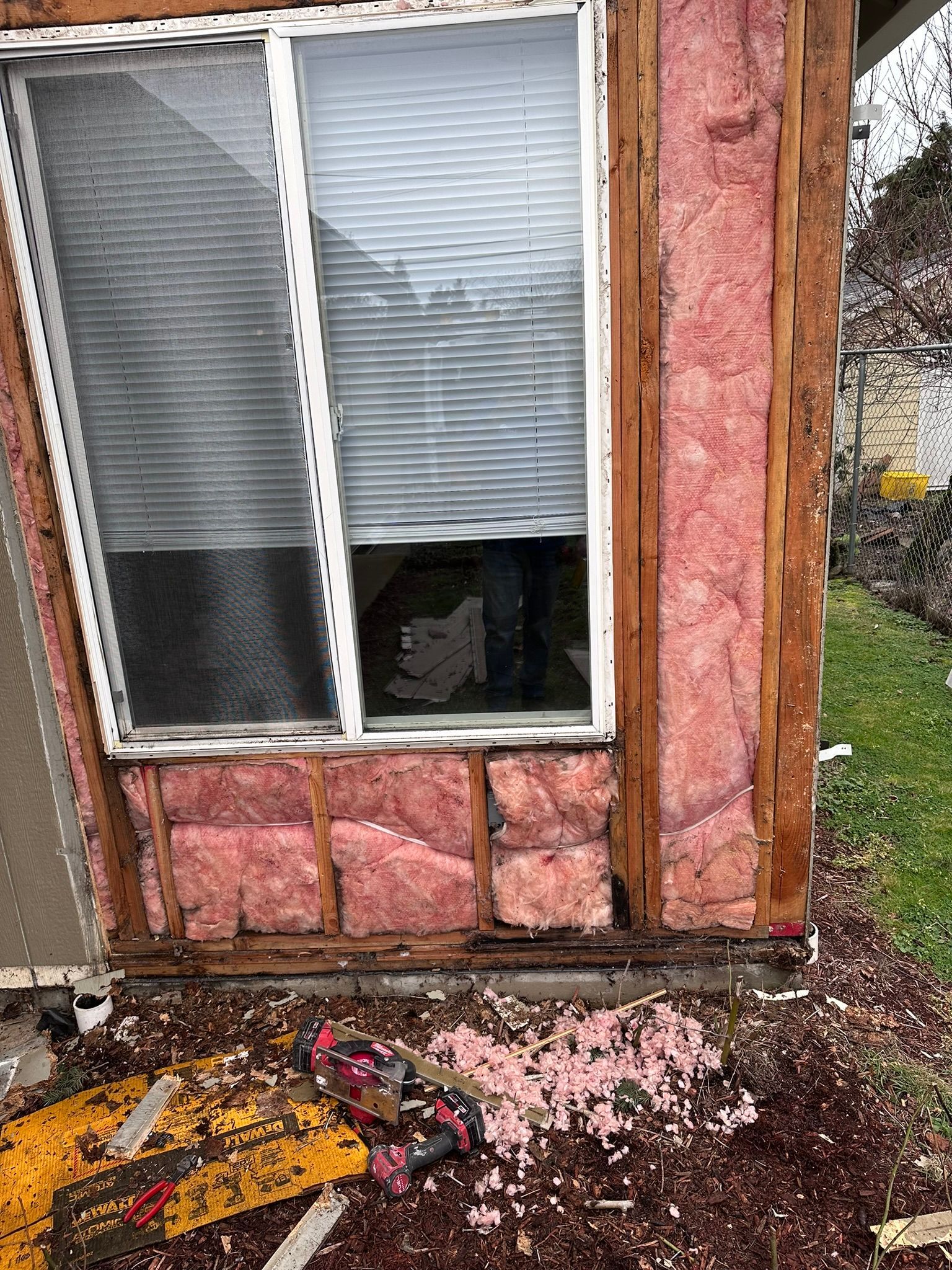 A house with pink insulation on the side of it and a window.