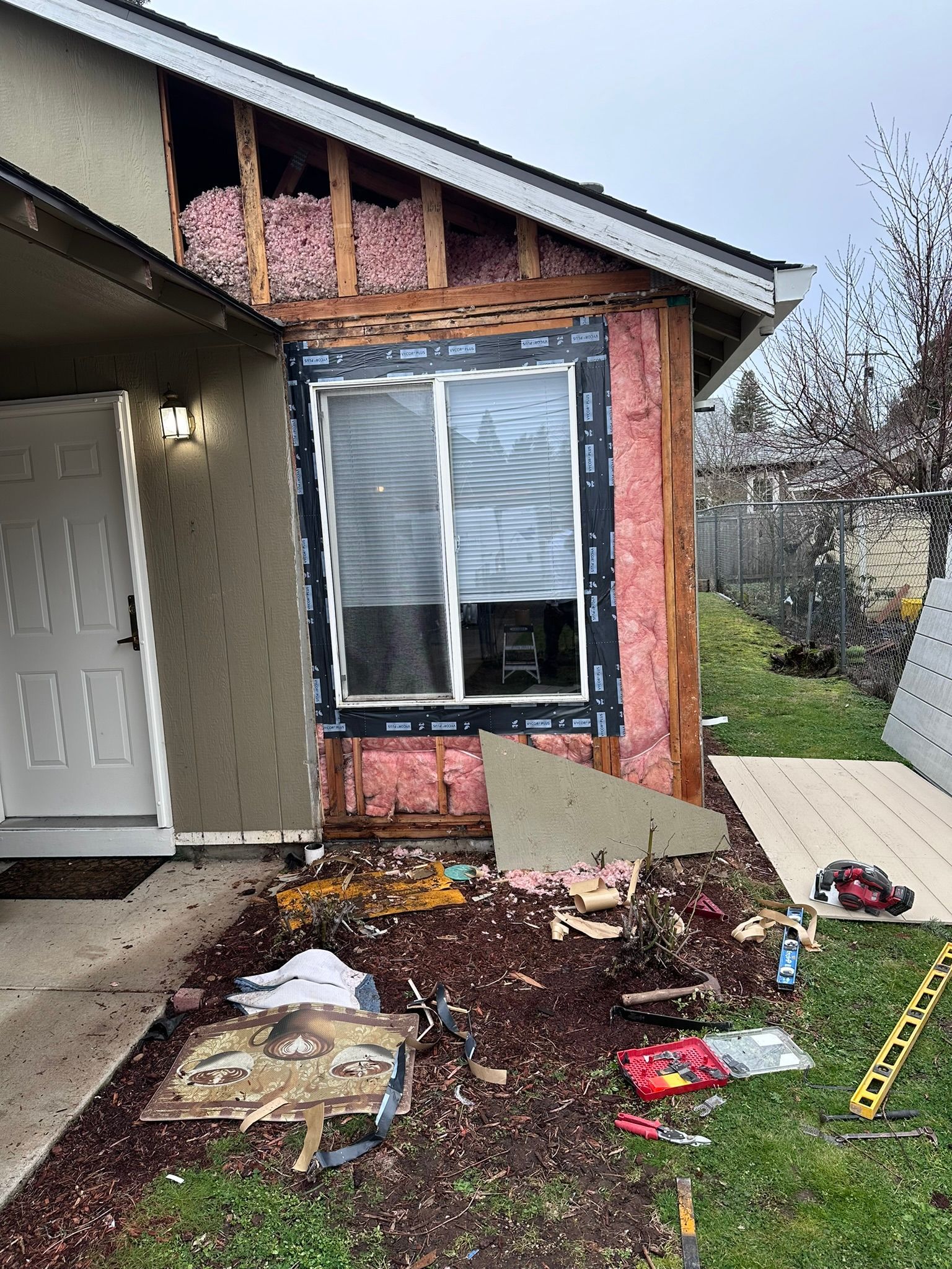 A house is being remodeled with a sliding glass door and a window.