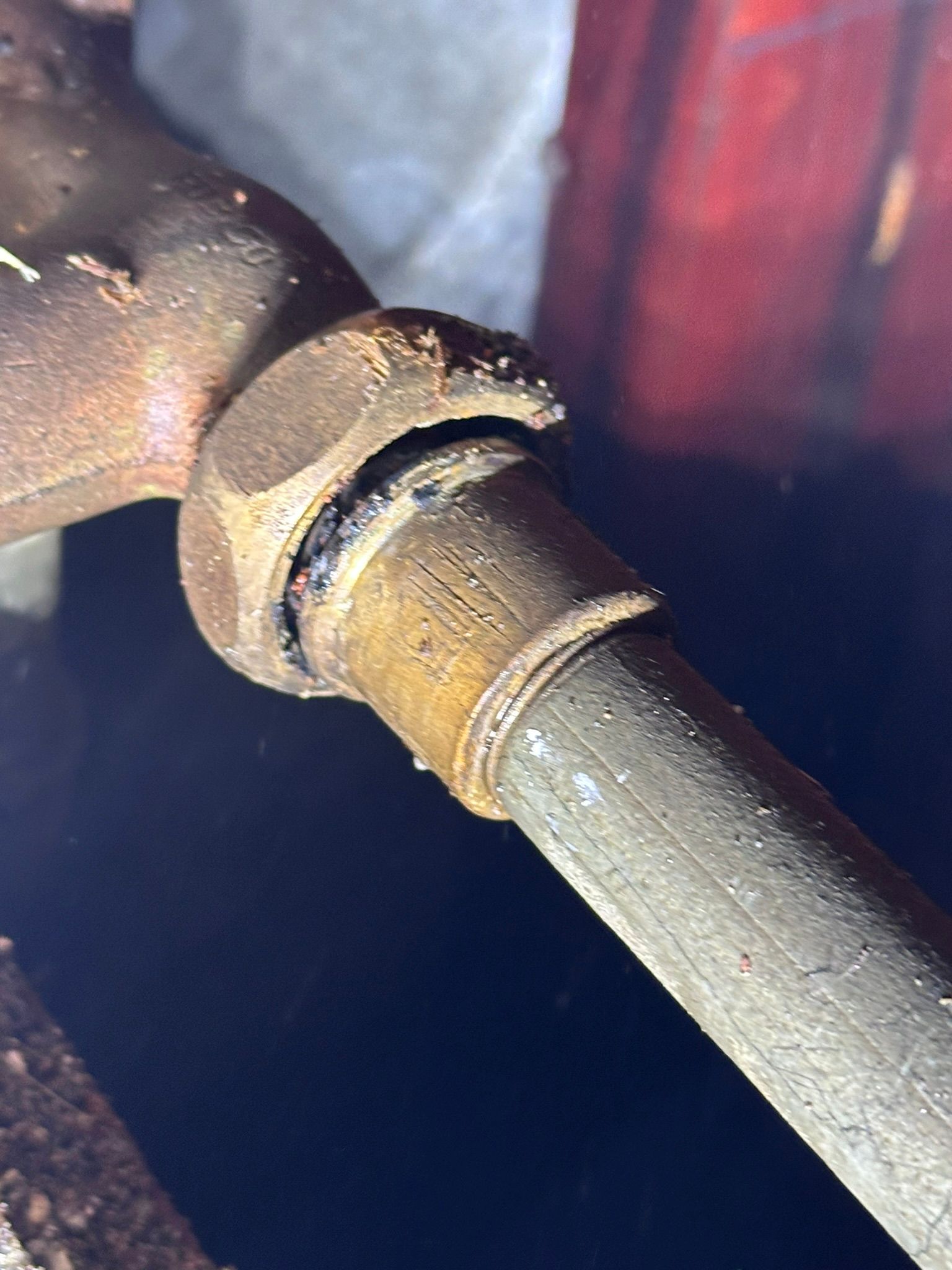 A close up of a rusty pipe with a nut on it.