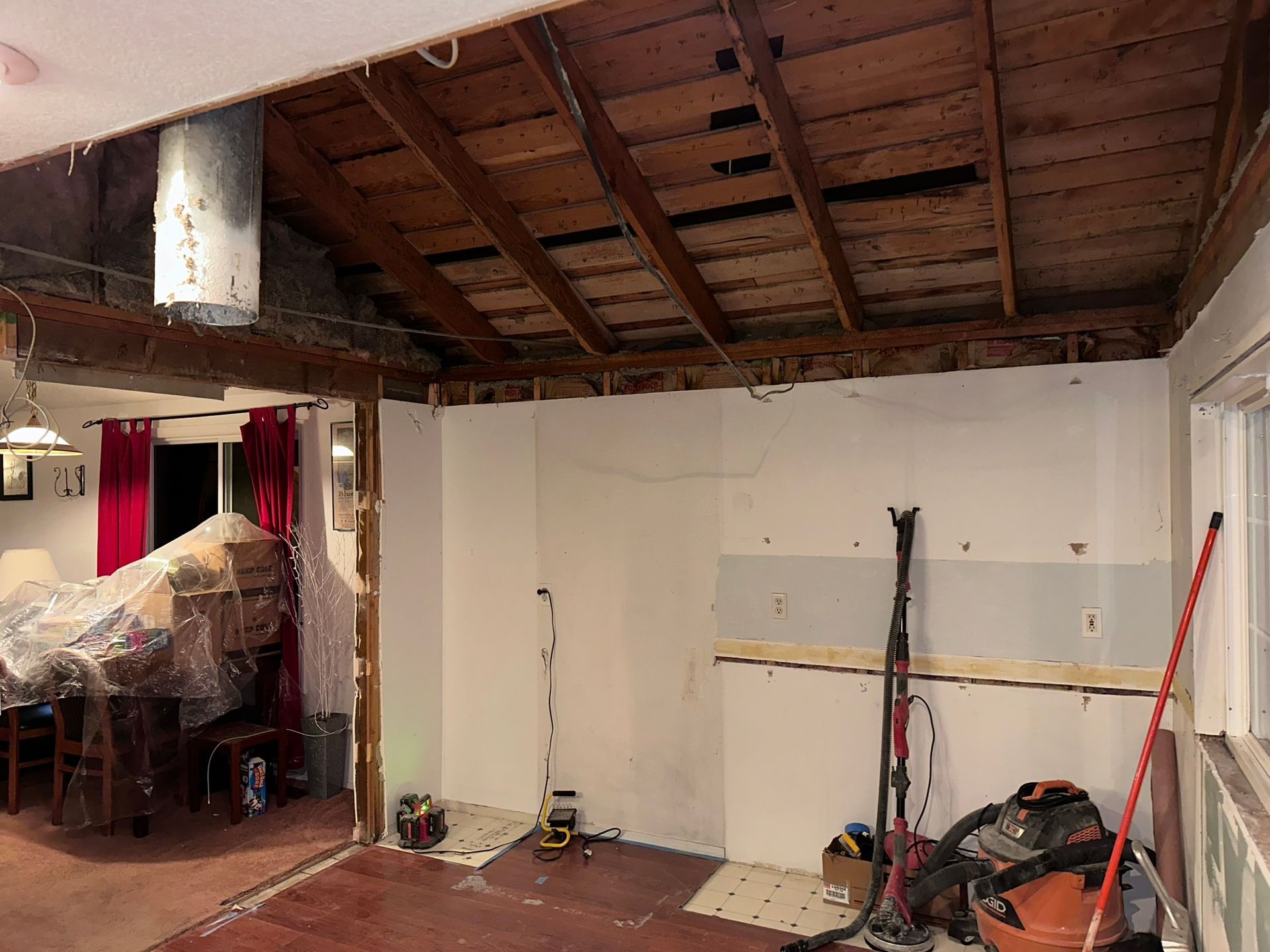A room with a wooden ceiling and a vacuum cleaner in it.