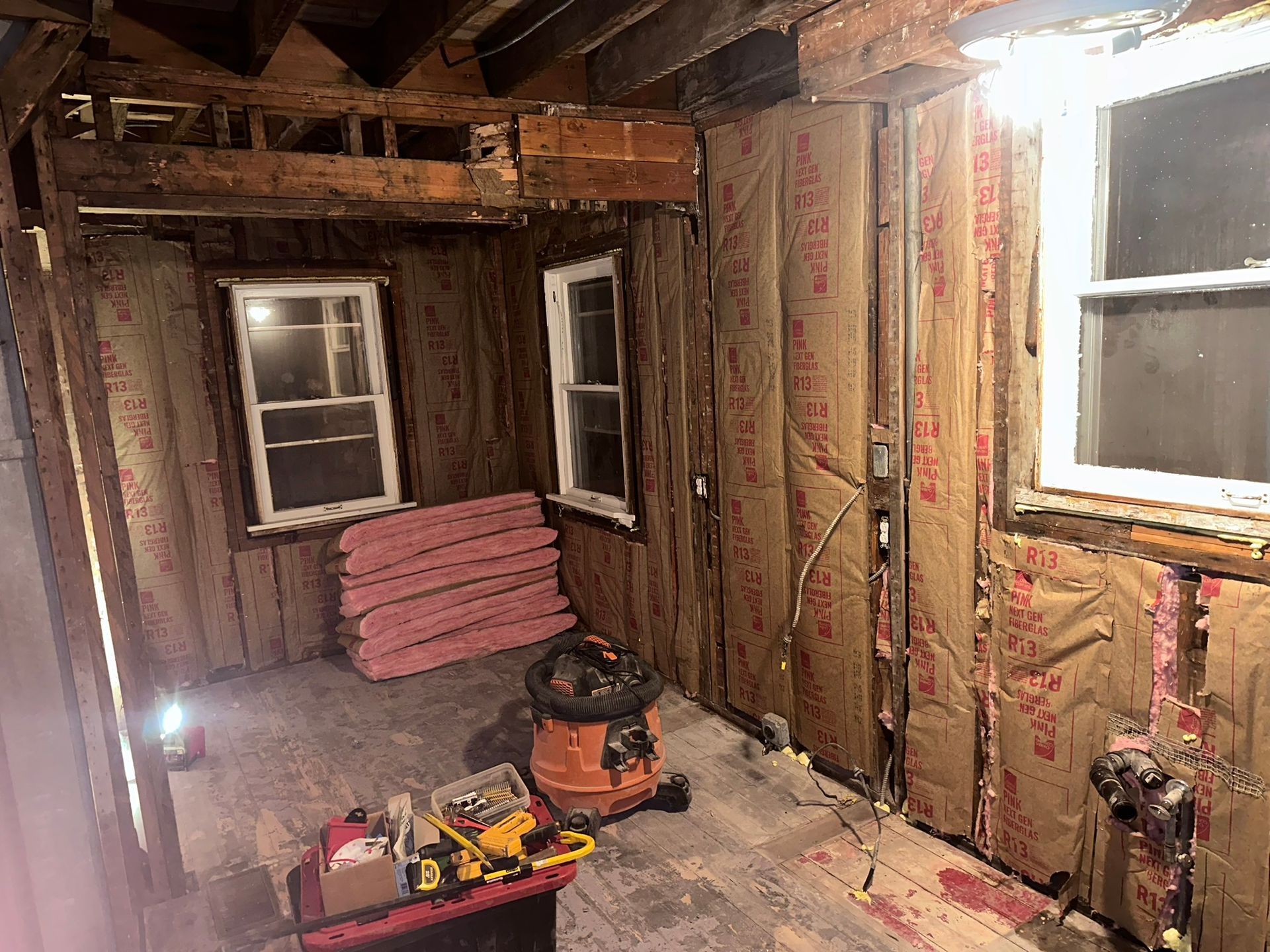 A room with a vacuum cleaner and tools in it.