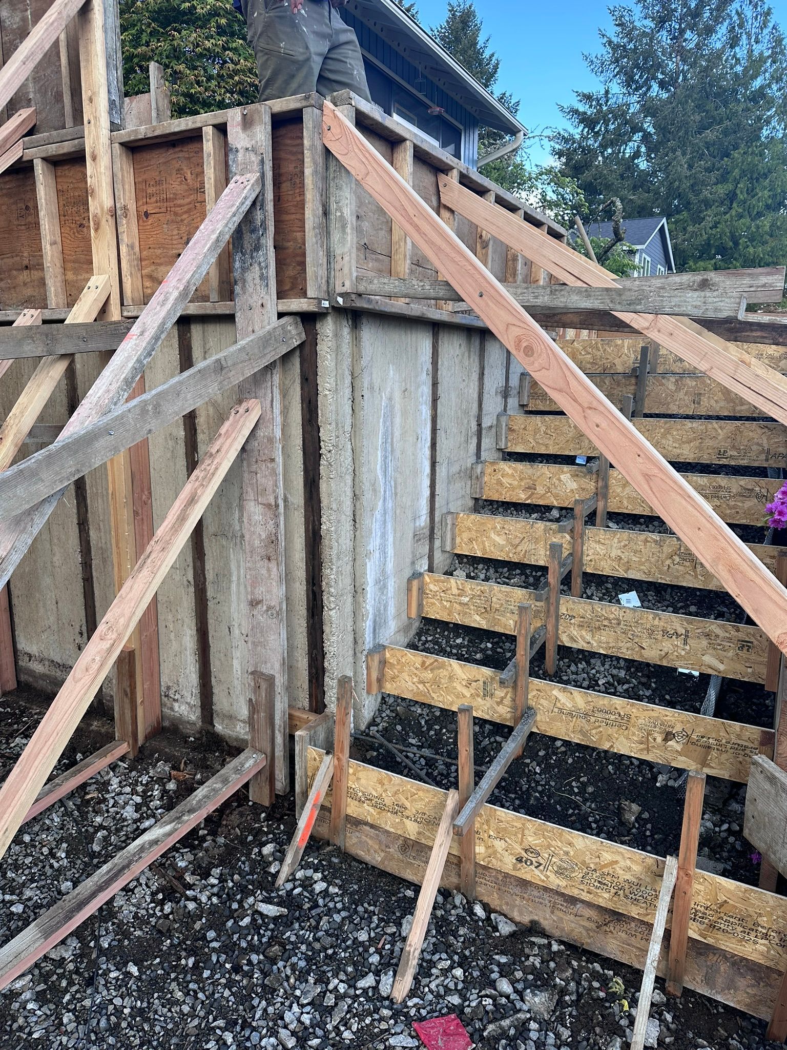 A wooden structure with stairs being built in front of a house.