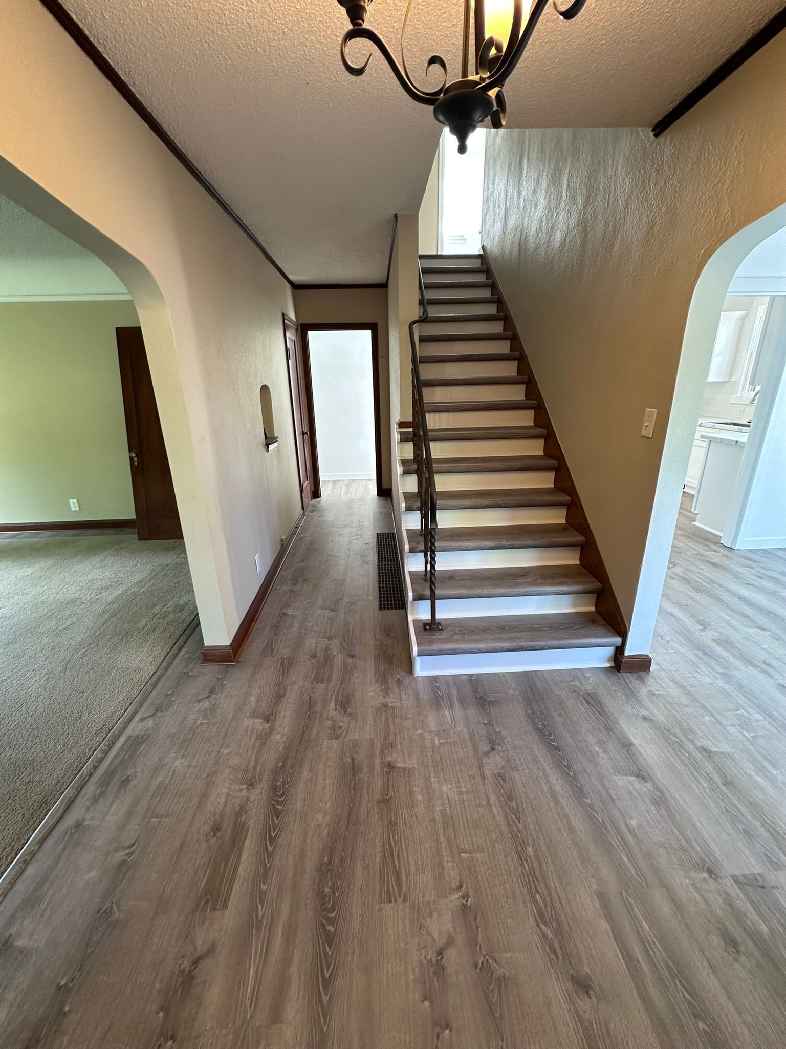 A hallway with stairs leading up to the second floor of a house.