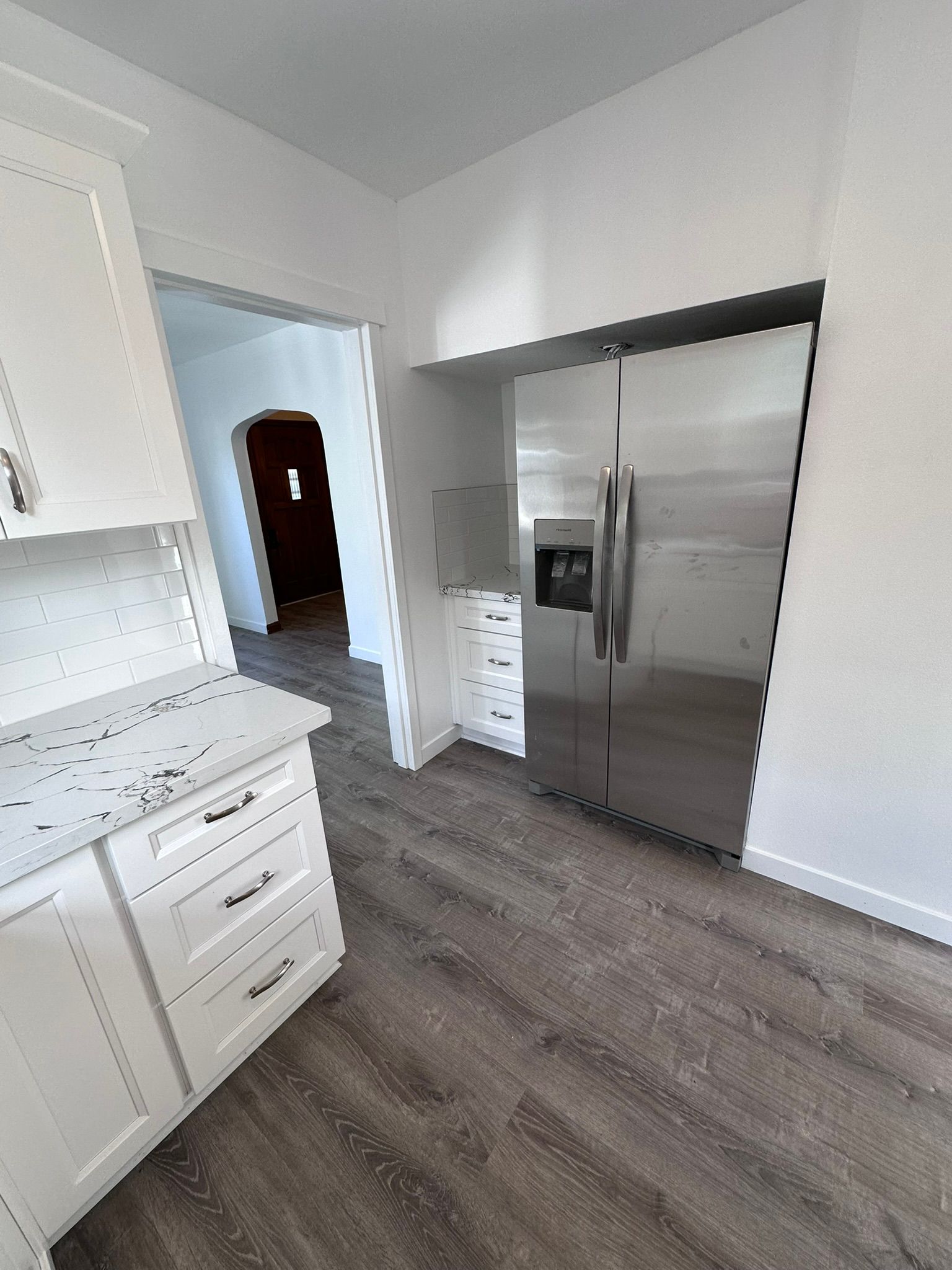 A kitchen with stainless steel appliances and white cabinets.