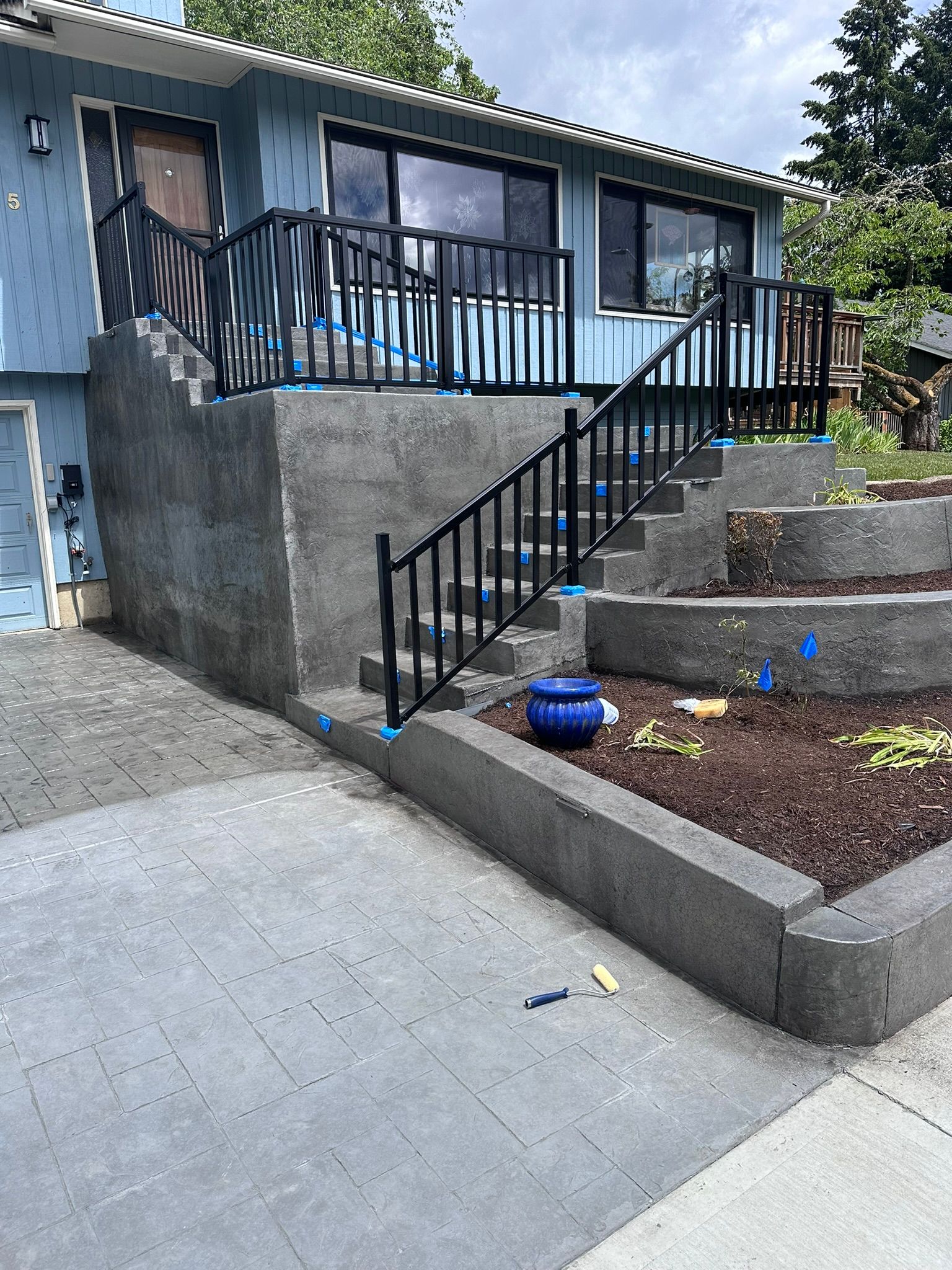 A blue house with stairs and a metal railing.