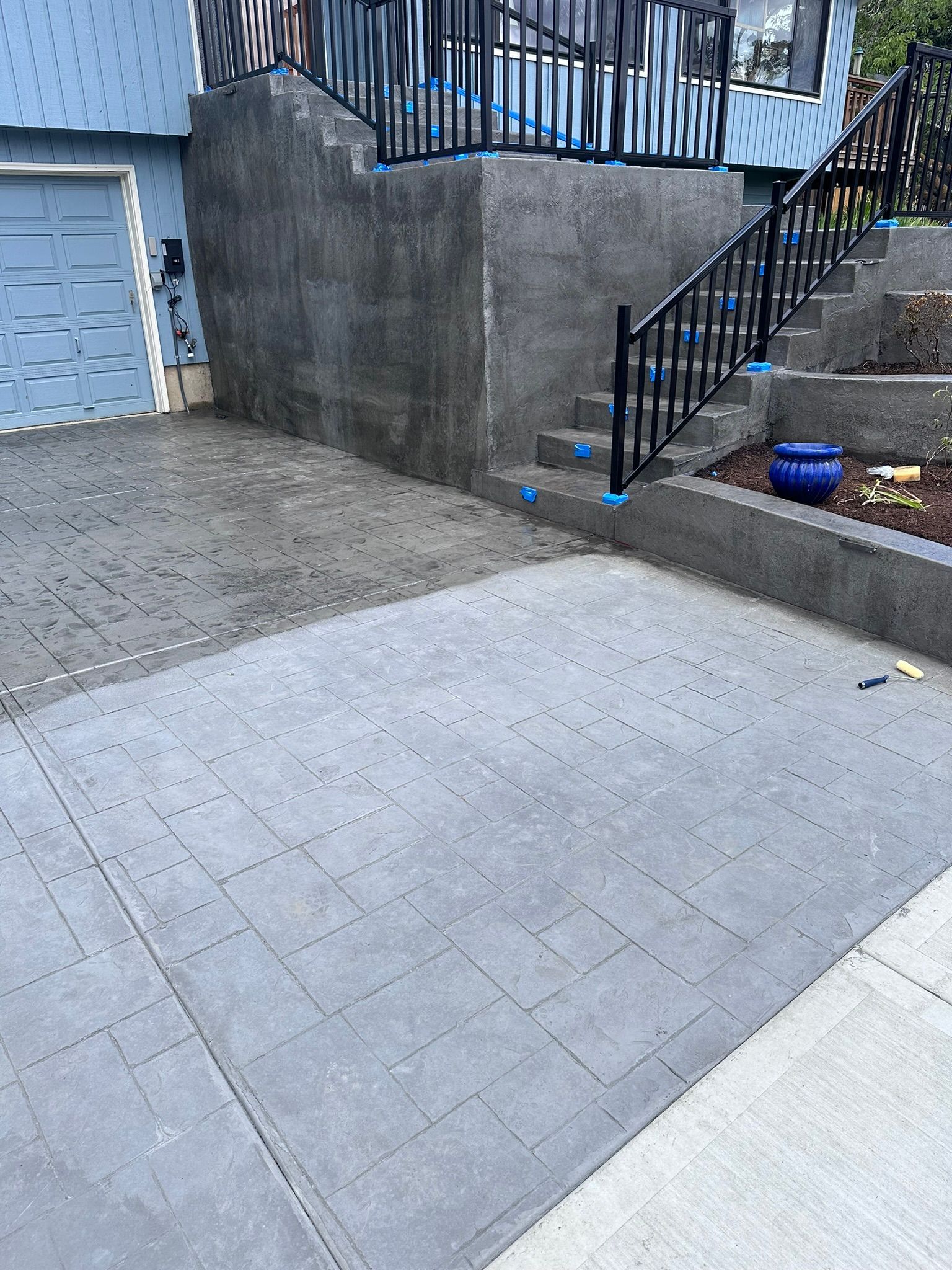 A concrete driveway with stairs leading up to a house.