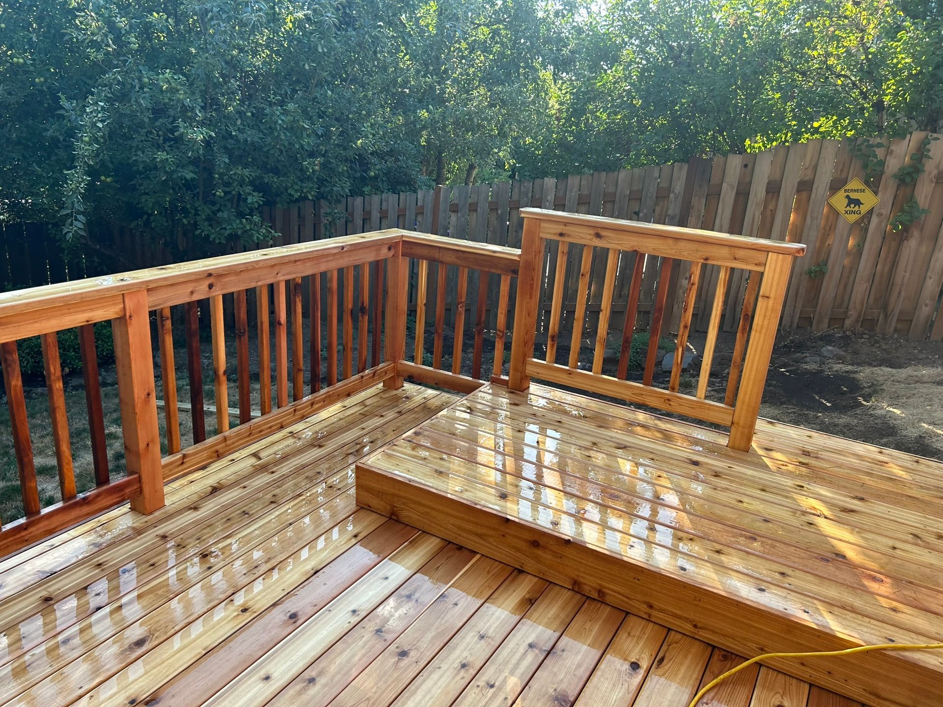A wooden deck with a fence in the background.