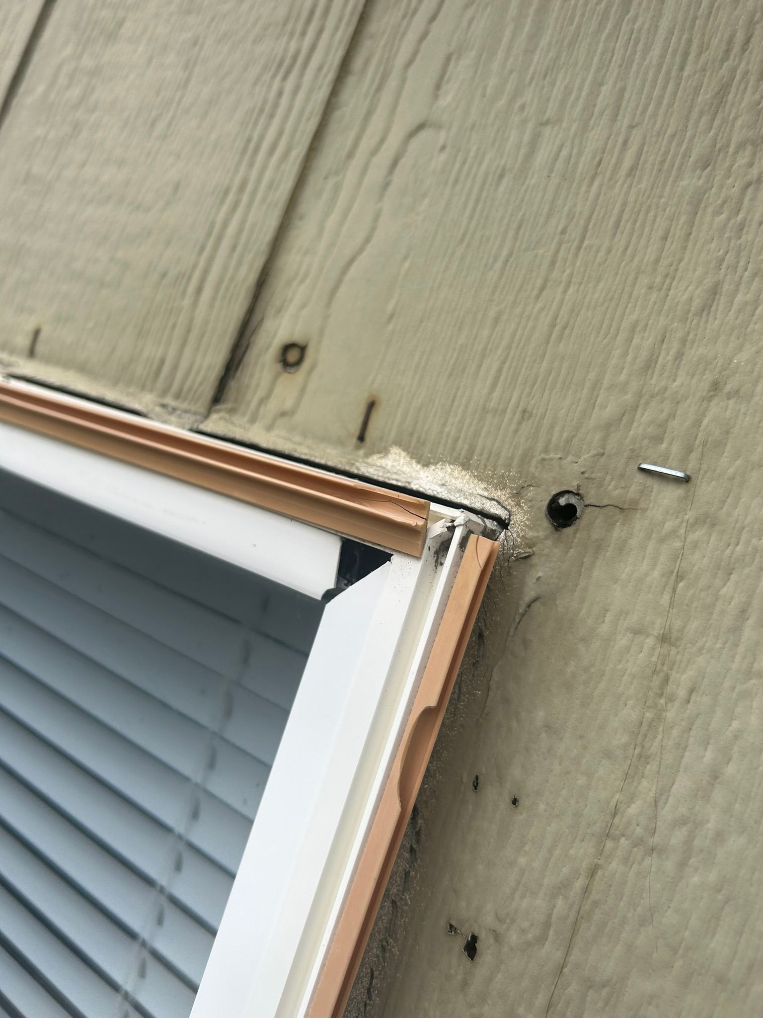 A close up of a window with blinds on a wooden wall.