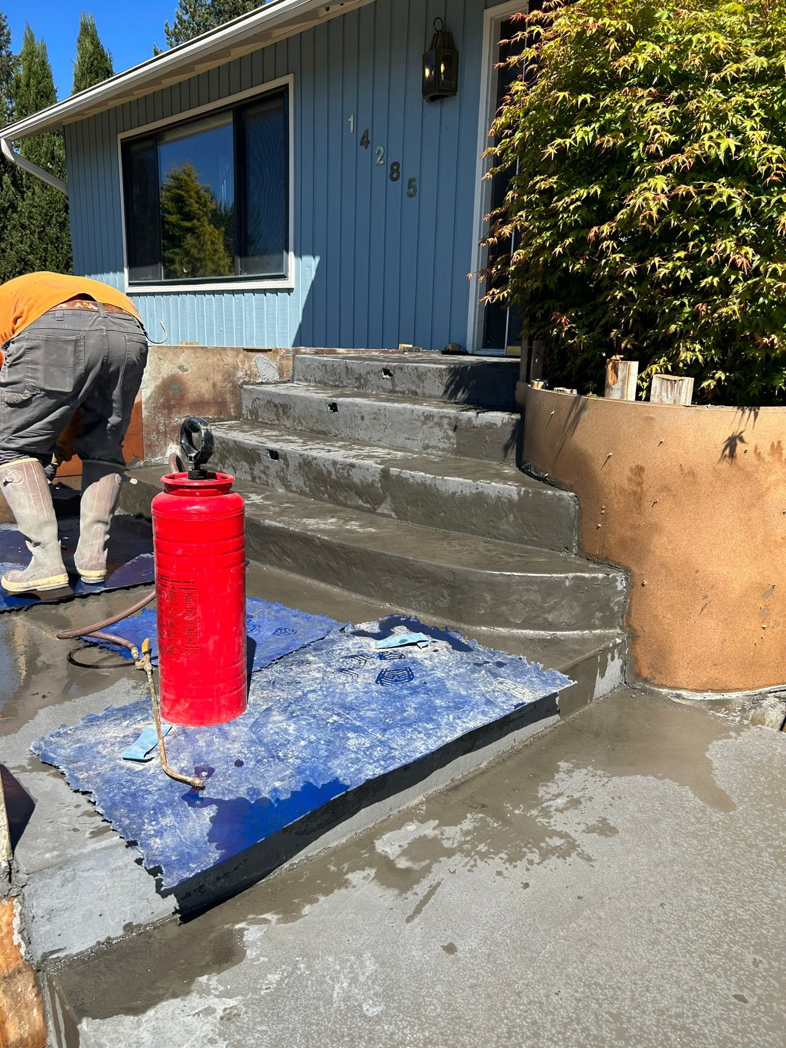 A man is working on the steps of a house.