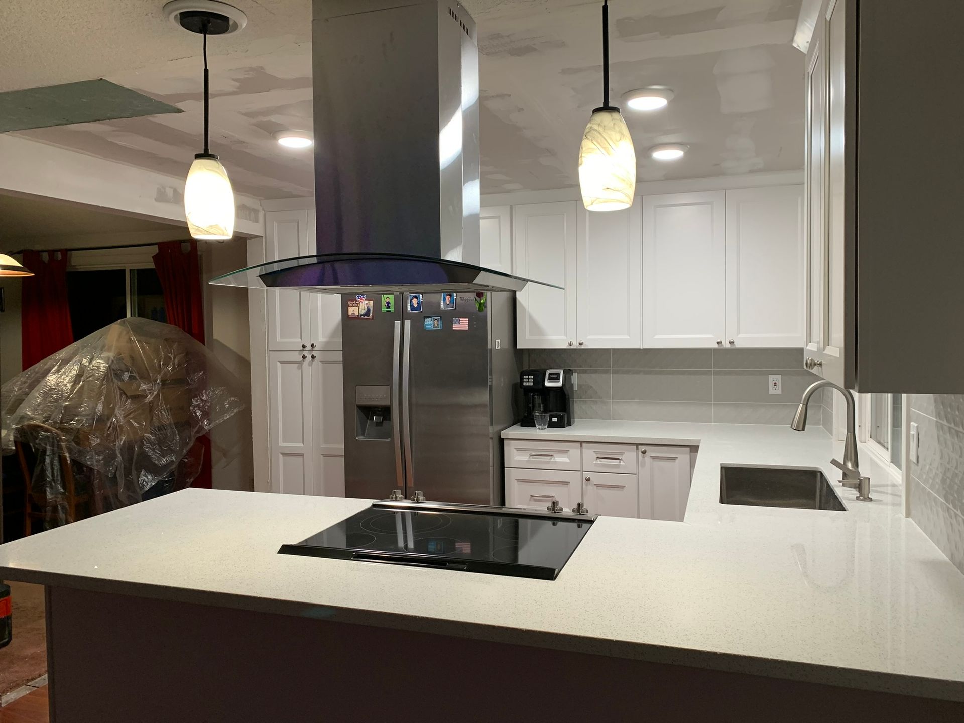 A kitchen with white cabinets and a stove top oven