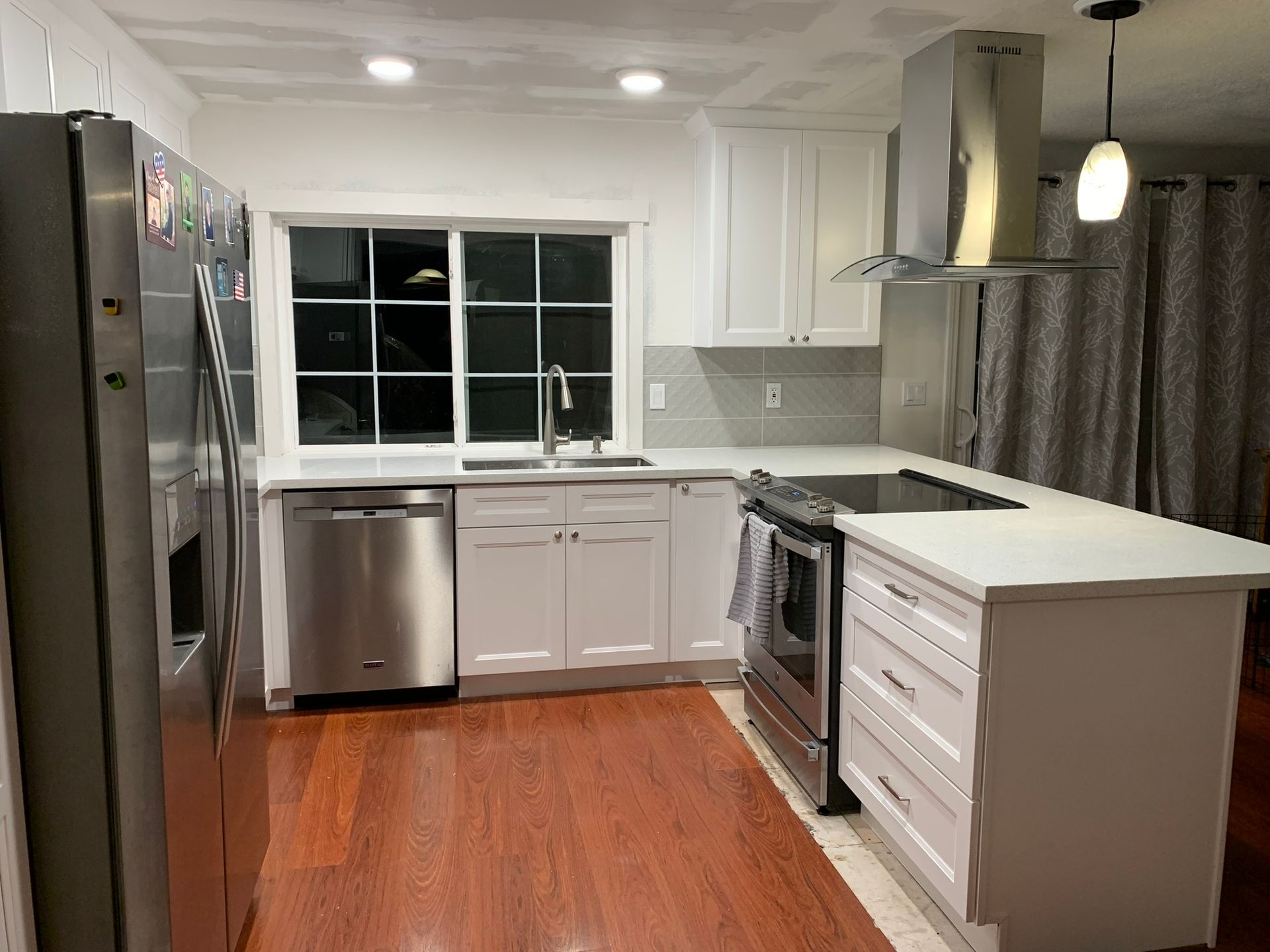 A kitchen with stainless steel appliances and white cabinets