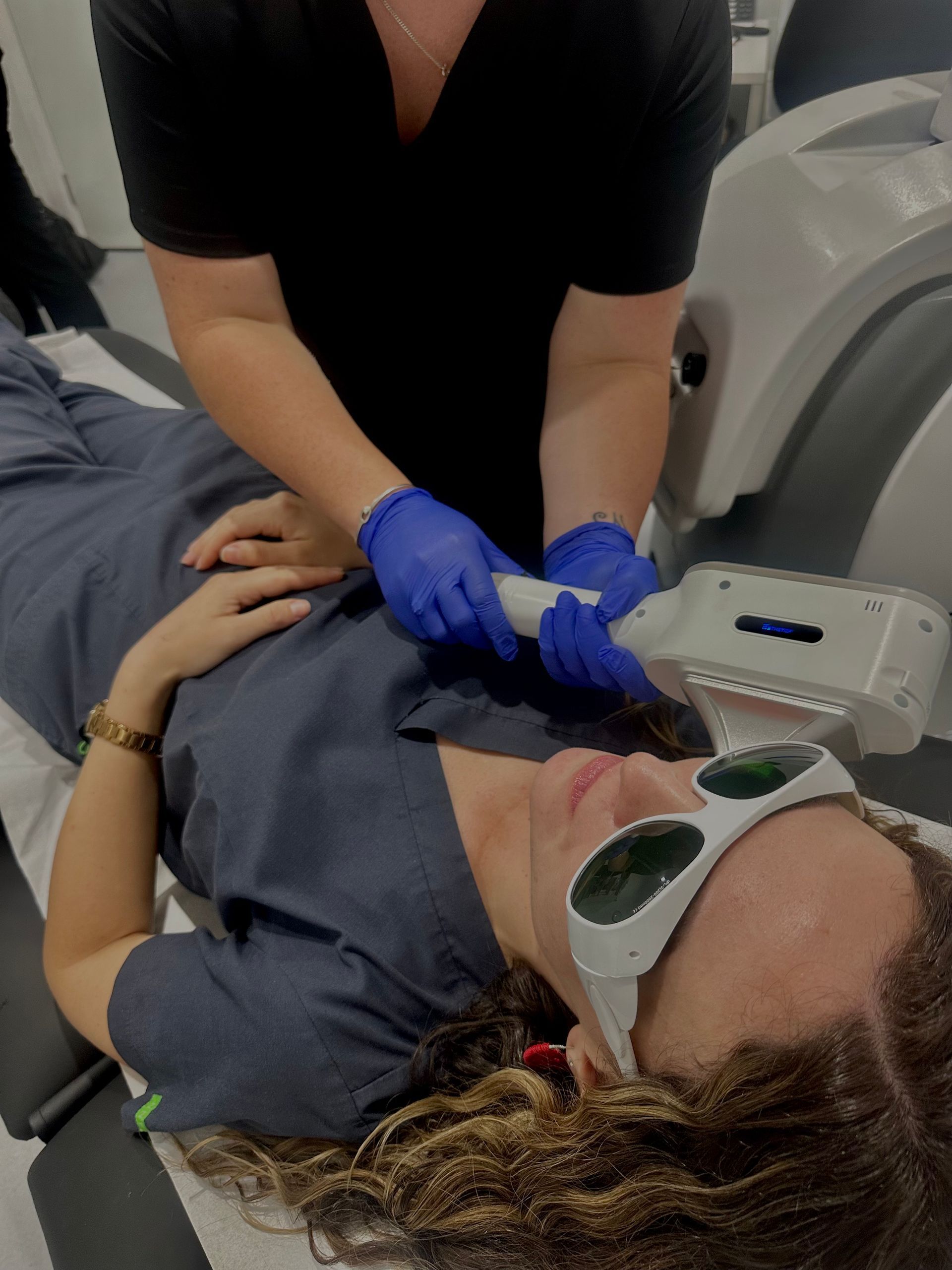 Woman Wearing Safety Glasses Receiving Laser Treatment at a Clinic — Hope Laser and Beauty Clinic In Tuncurry, NSW
