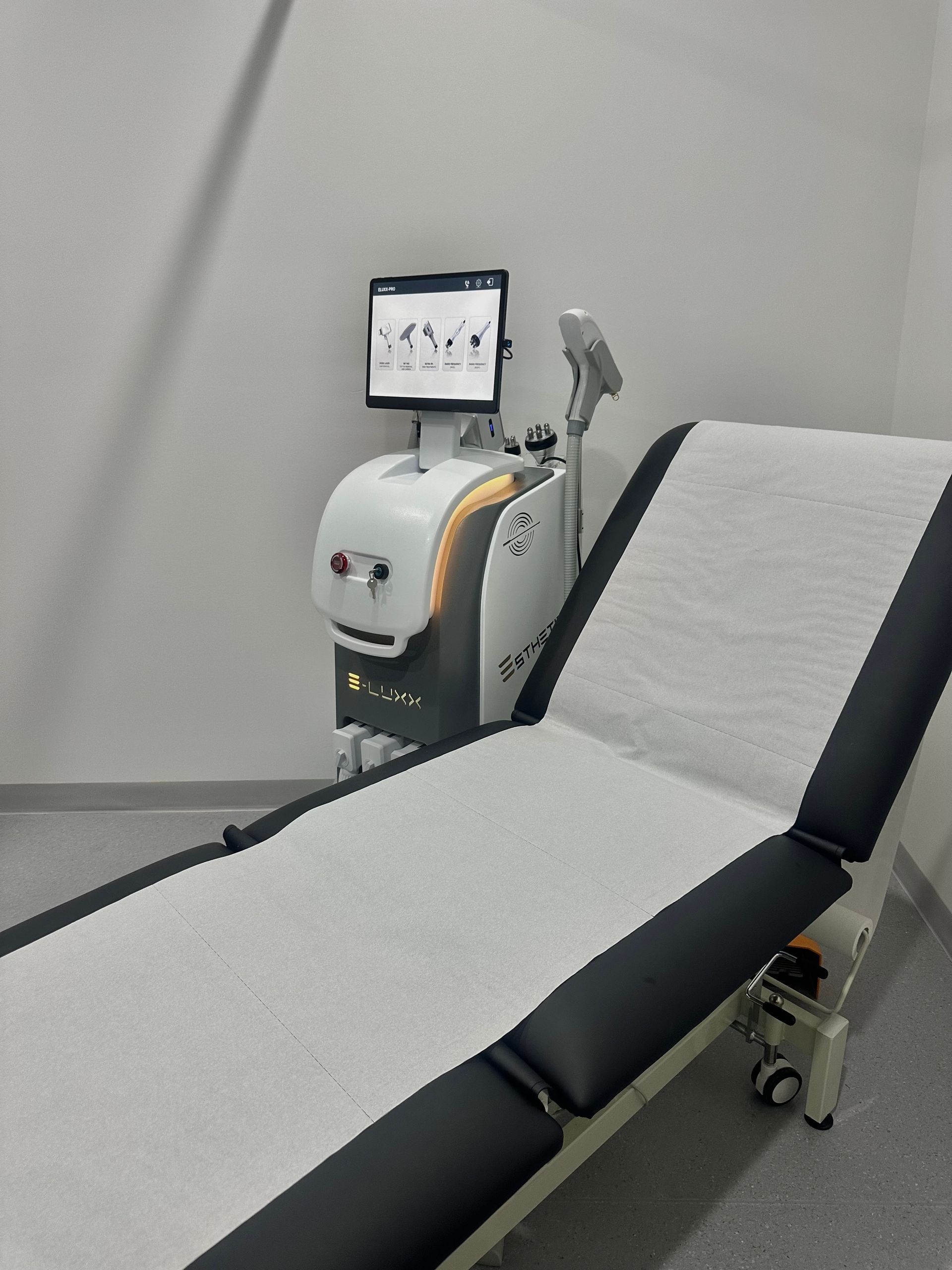 Treatment room with medical bed and laser machine. — Hope Laser and Beauty Clinic In Tuncurry, NSW