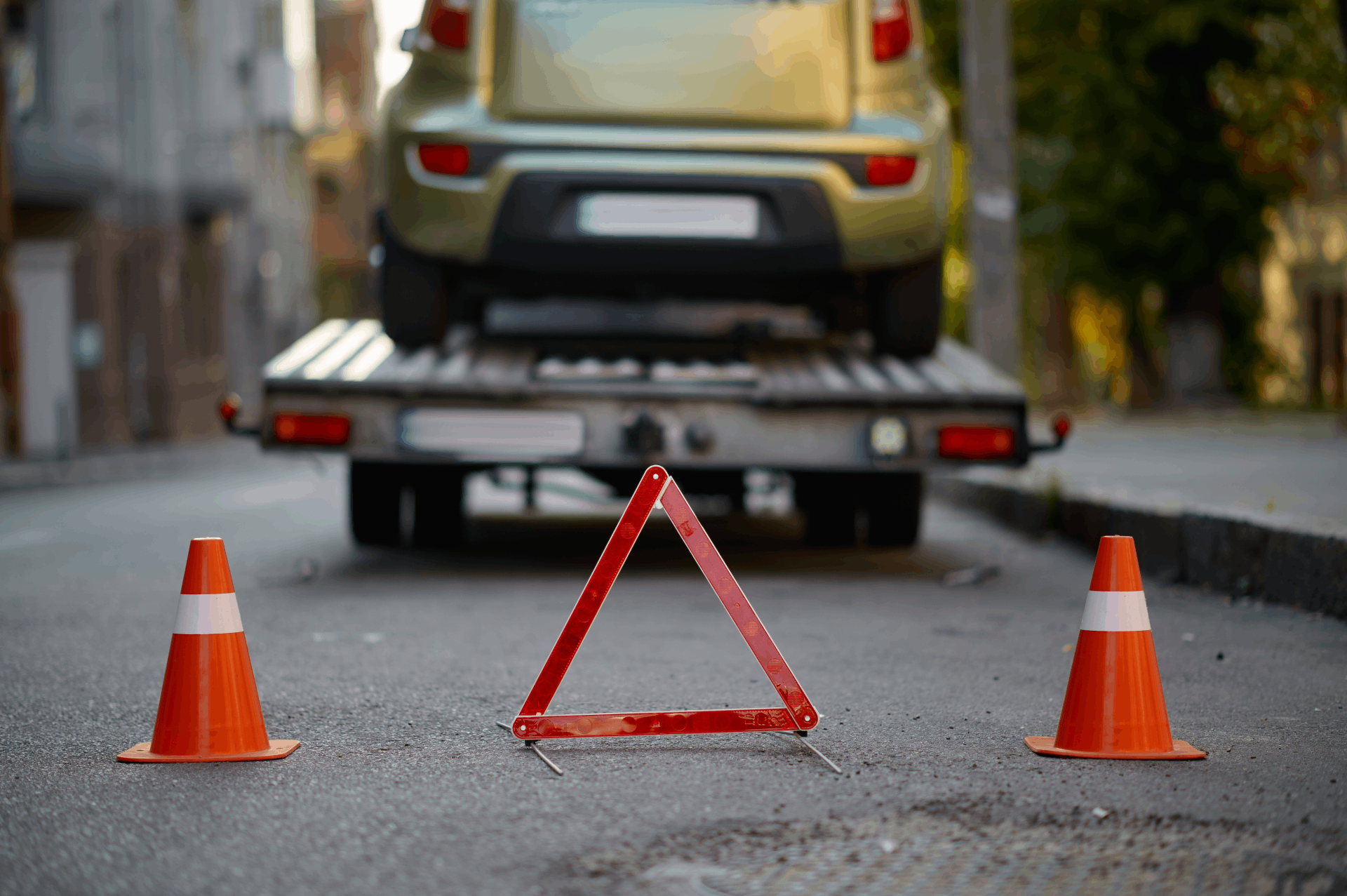 A Car Is Being Towed Down the Street by A Tow Truck.