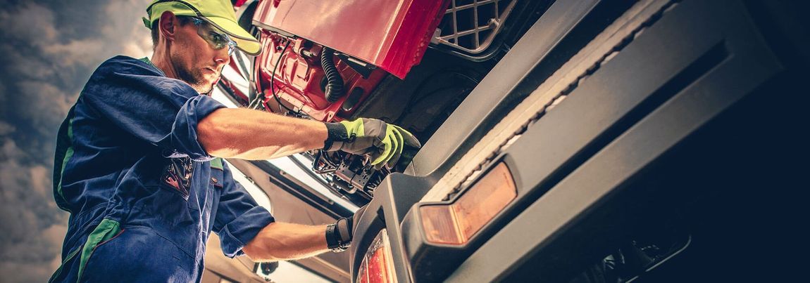 A Man Is Working on The Side of A Truck.