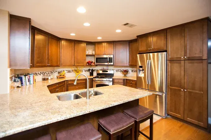 Kitchen with brown cabinets, stainless steel appliances, and granite countertops.