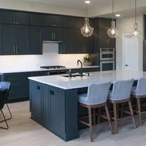 Modern kitchen with dark blue cabinets, island, and seating.