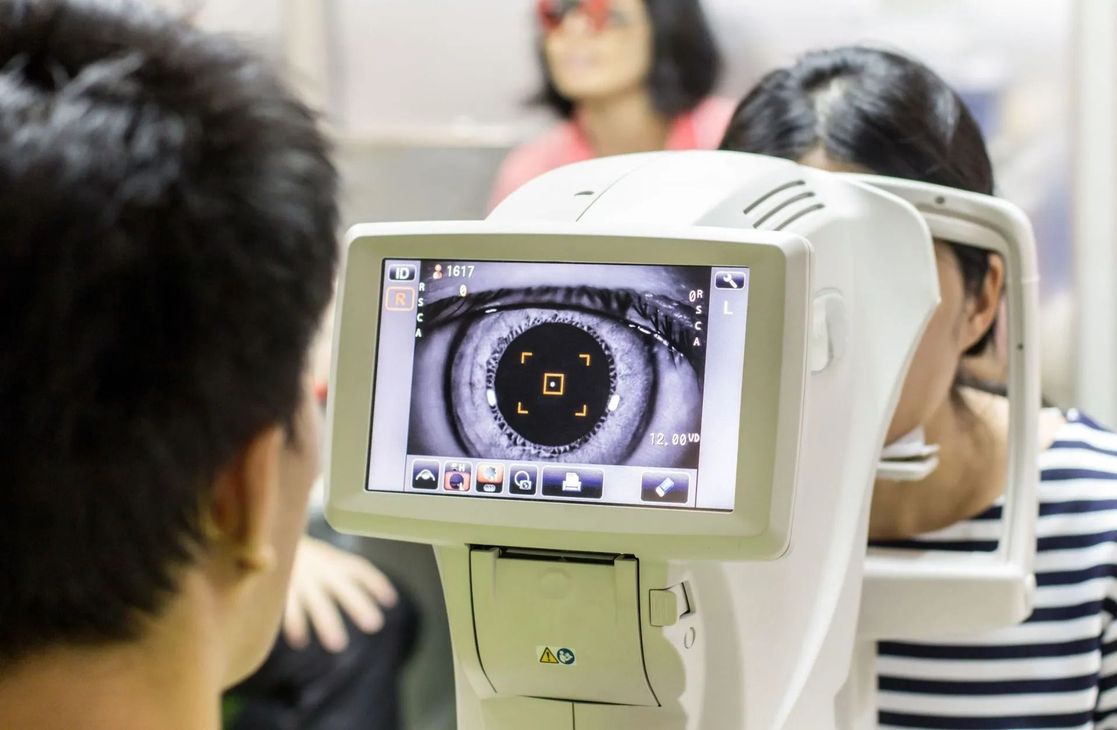 Esame della vista: una persona che utilizza un dispositivo medico per esaminare l'occhio di un'altra persona.