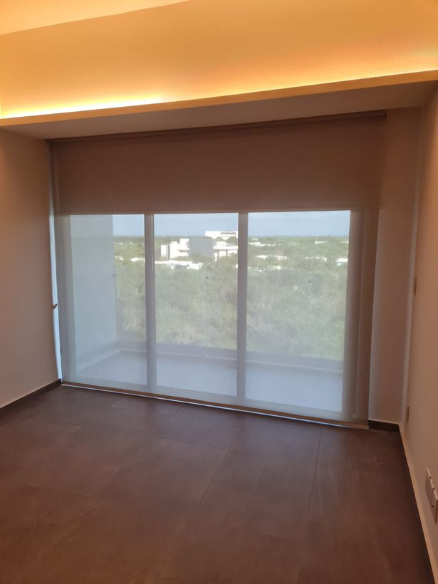 Una habitación con una ventana grande y persianas.