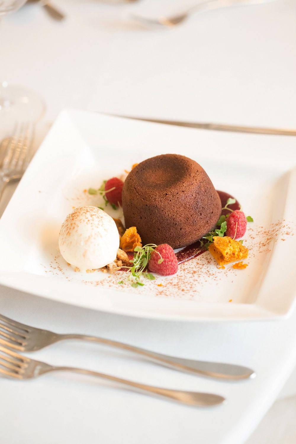 a white plate topped with a chocolate cake and ice cream on a table .