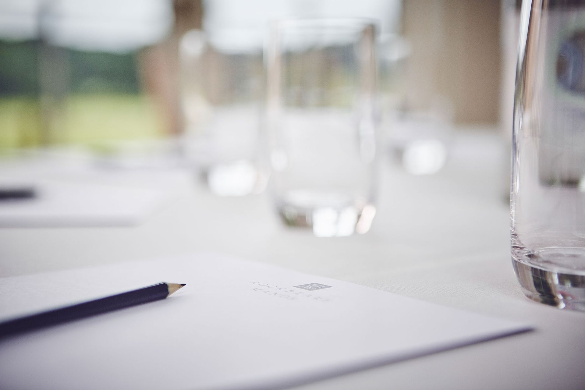 there is a pencil and a glass of water on the table .