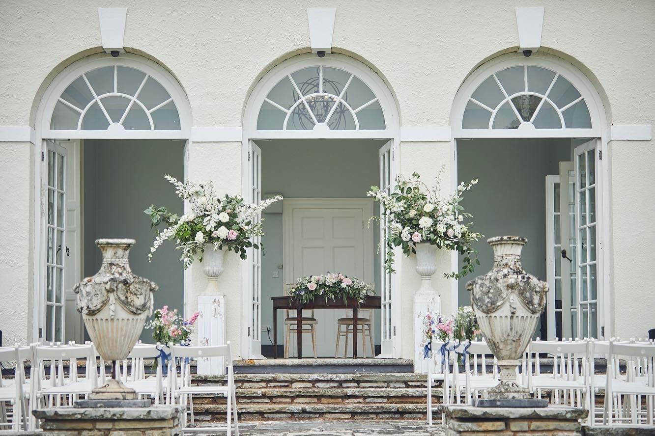 a row of vases filled with flowers are sitting on the steps of a building .