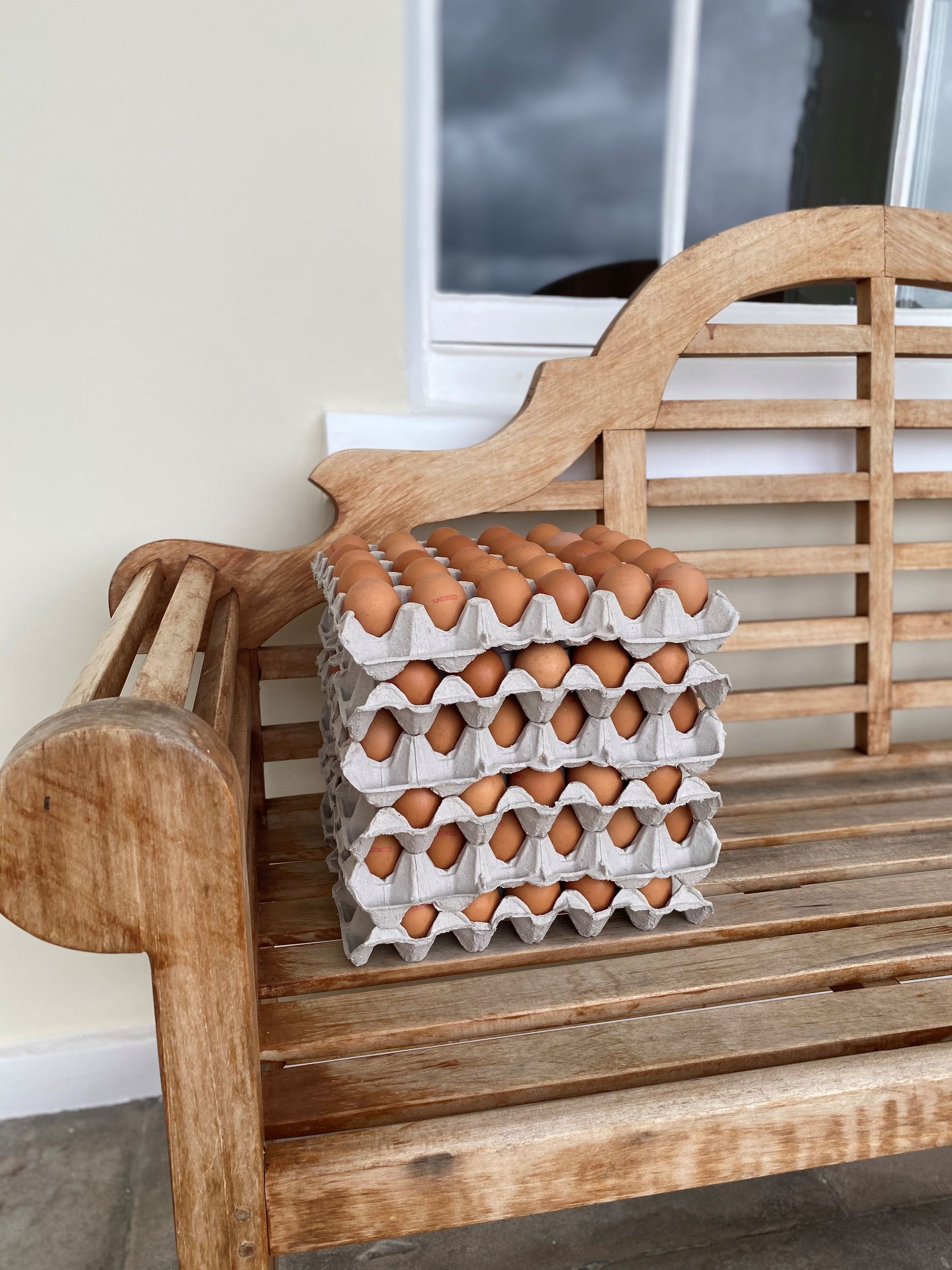 A wooden bench with a stack of eggs on it.