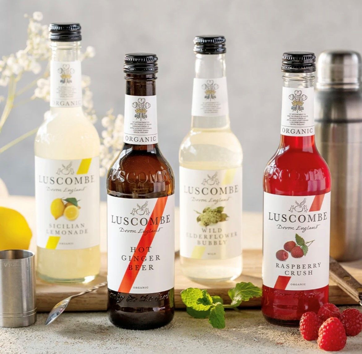 Four bottles of luscombe drinks are lined up on a table