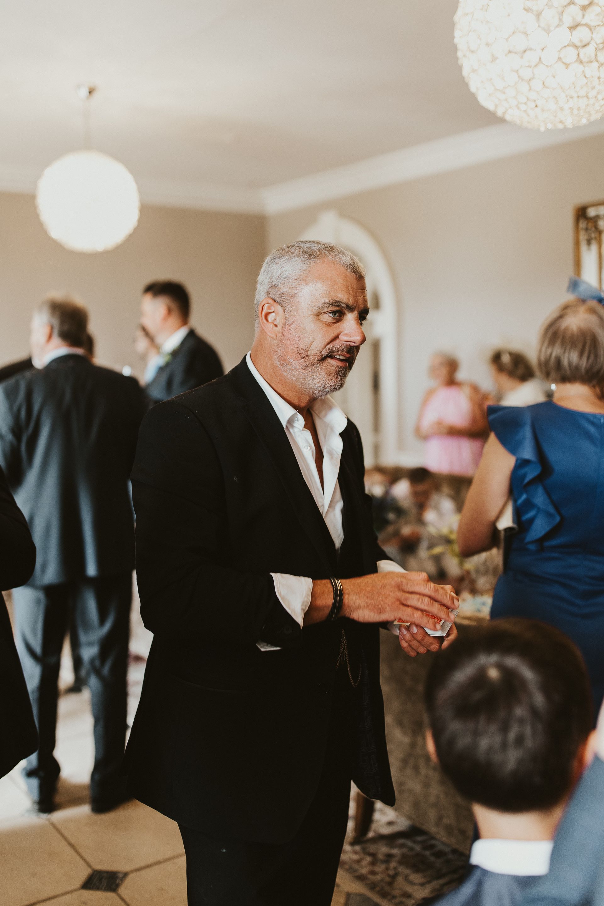 a man in a suit is standing in a room with a group of people .