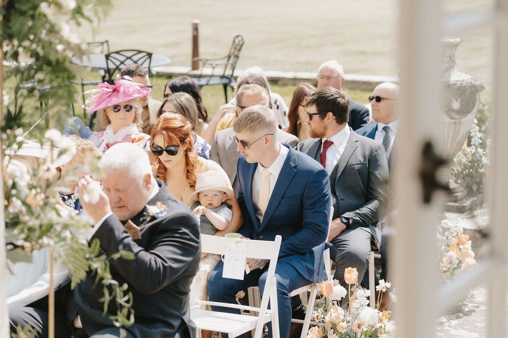 a bride and groom are sitting at a table signing a wedding register .