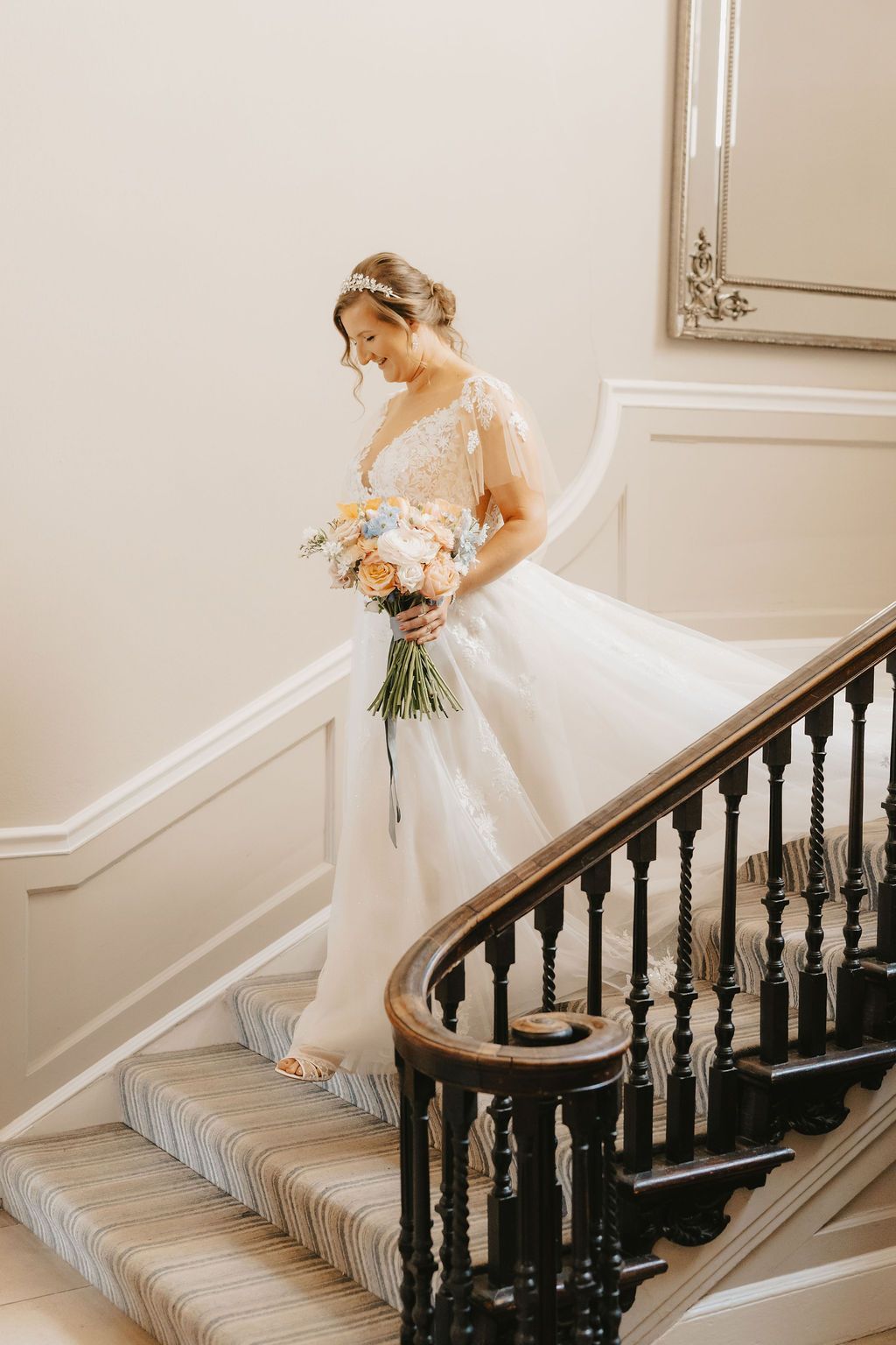 a bride is standing next to a group of women sitting on a couch in front of a fireplace .