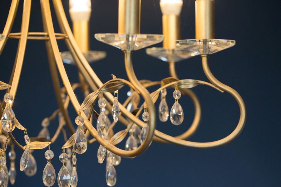 a close up of a gold chandelier with crystals hanging from it .