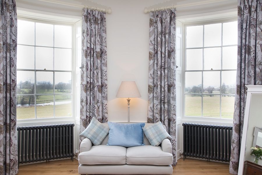 a living room with a couch and two windows