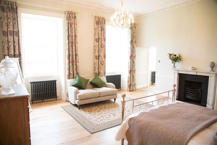 a bedroom with a bed , couch , fireplace and window .