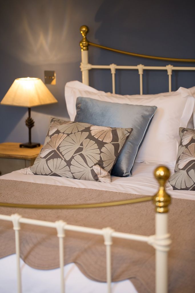 a bed with a lamp and pillows on it in a bedroom .