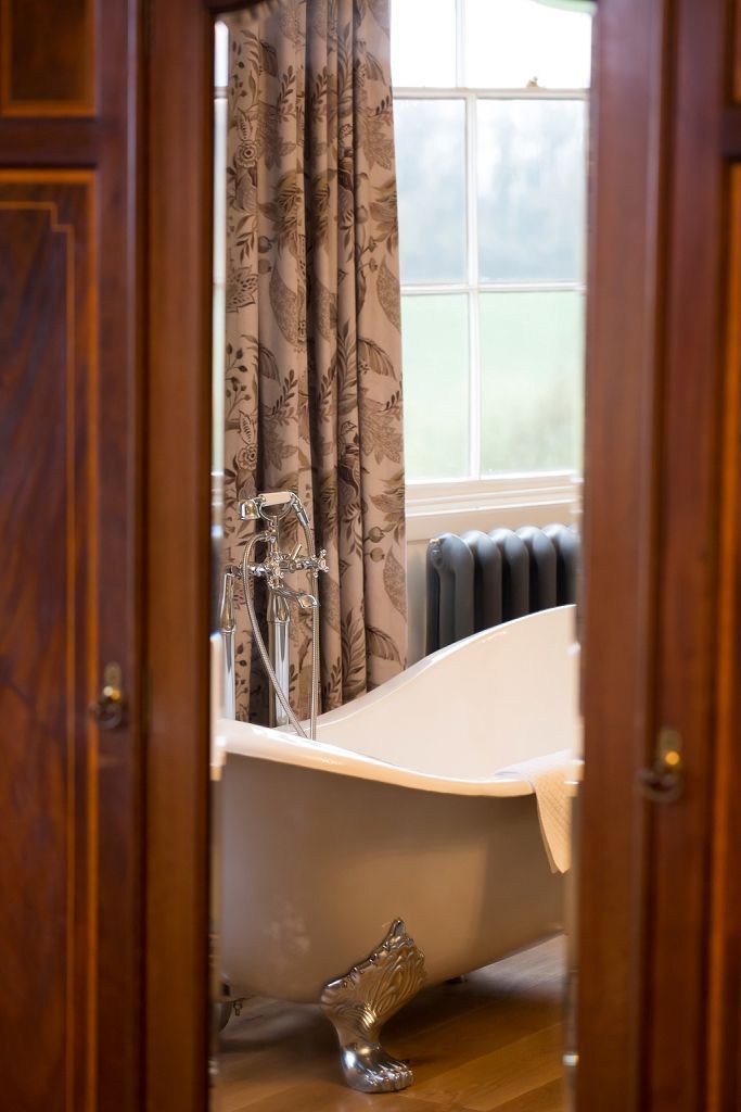 a bathroom with a claw foot tub and a window .