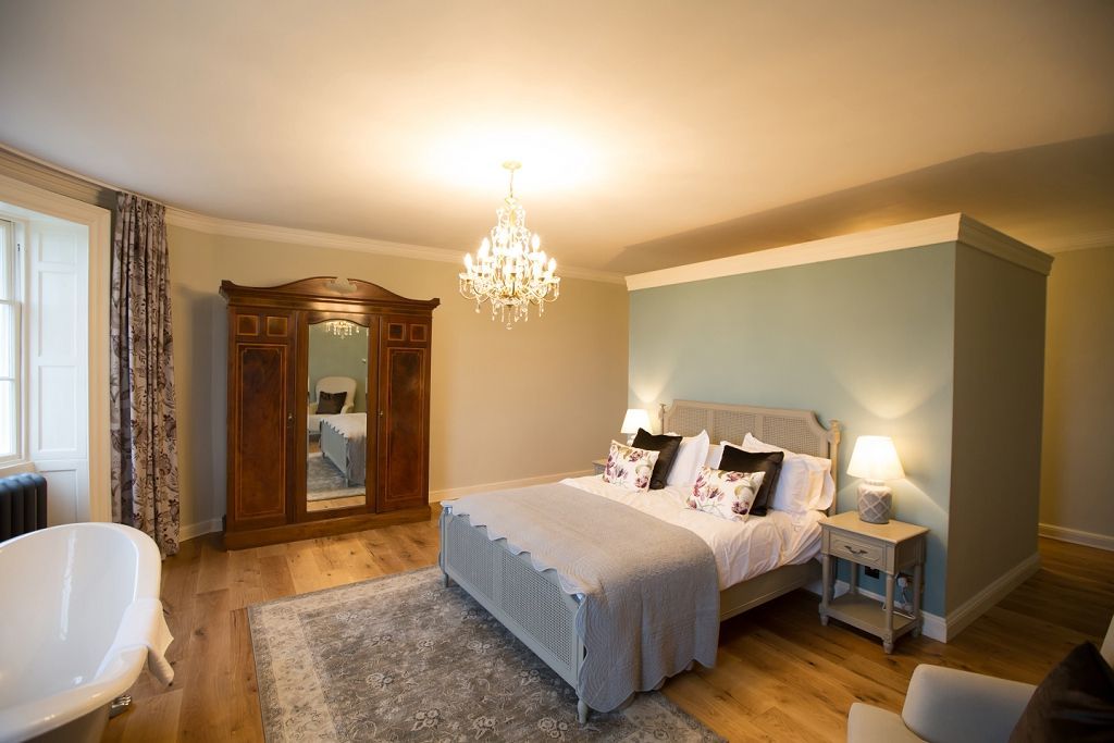 a large bedroom with a king size bed and a bathtub .