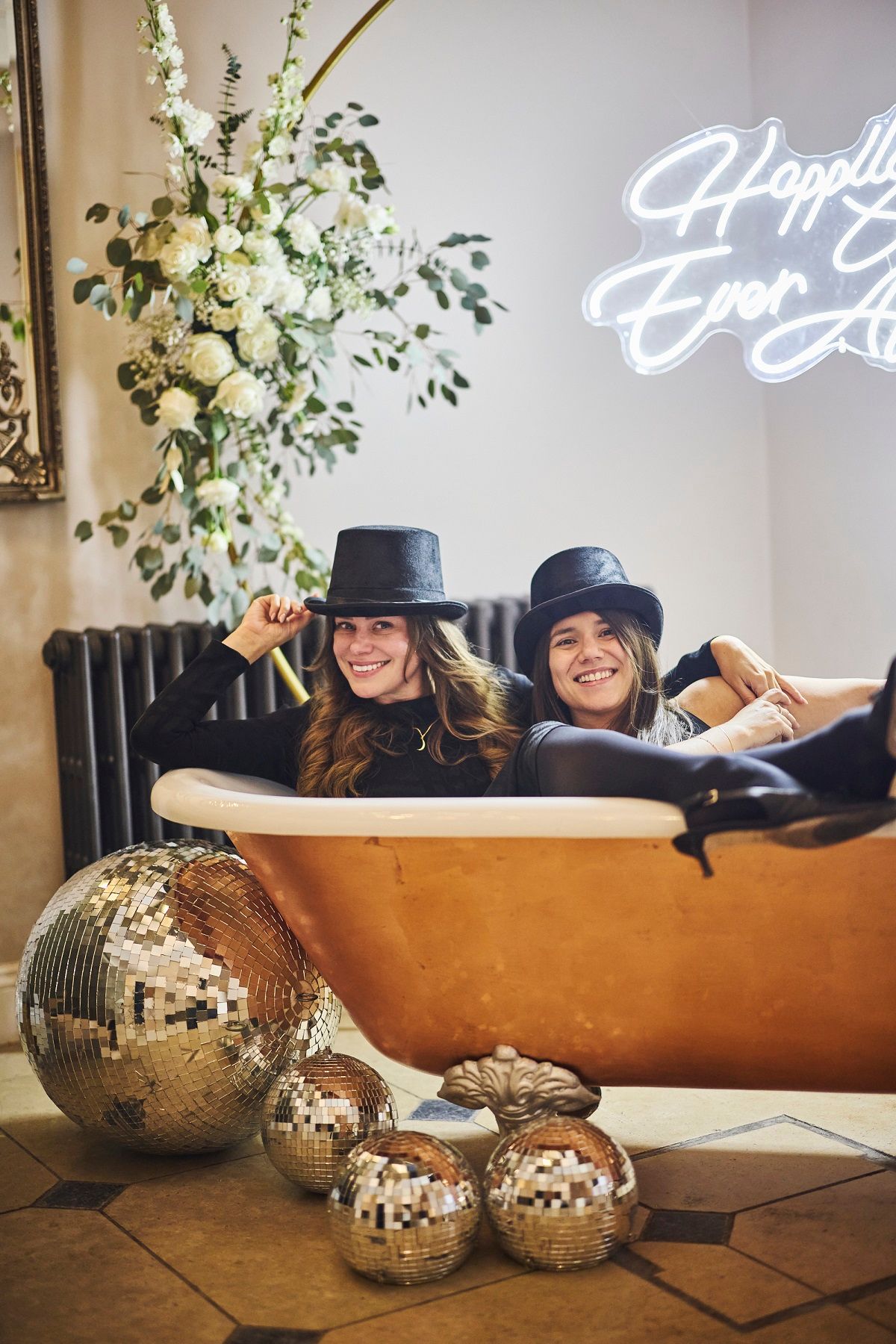 a black and white photo of a bride and groom walking in a field .