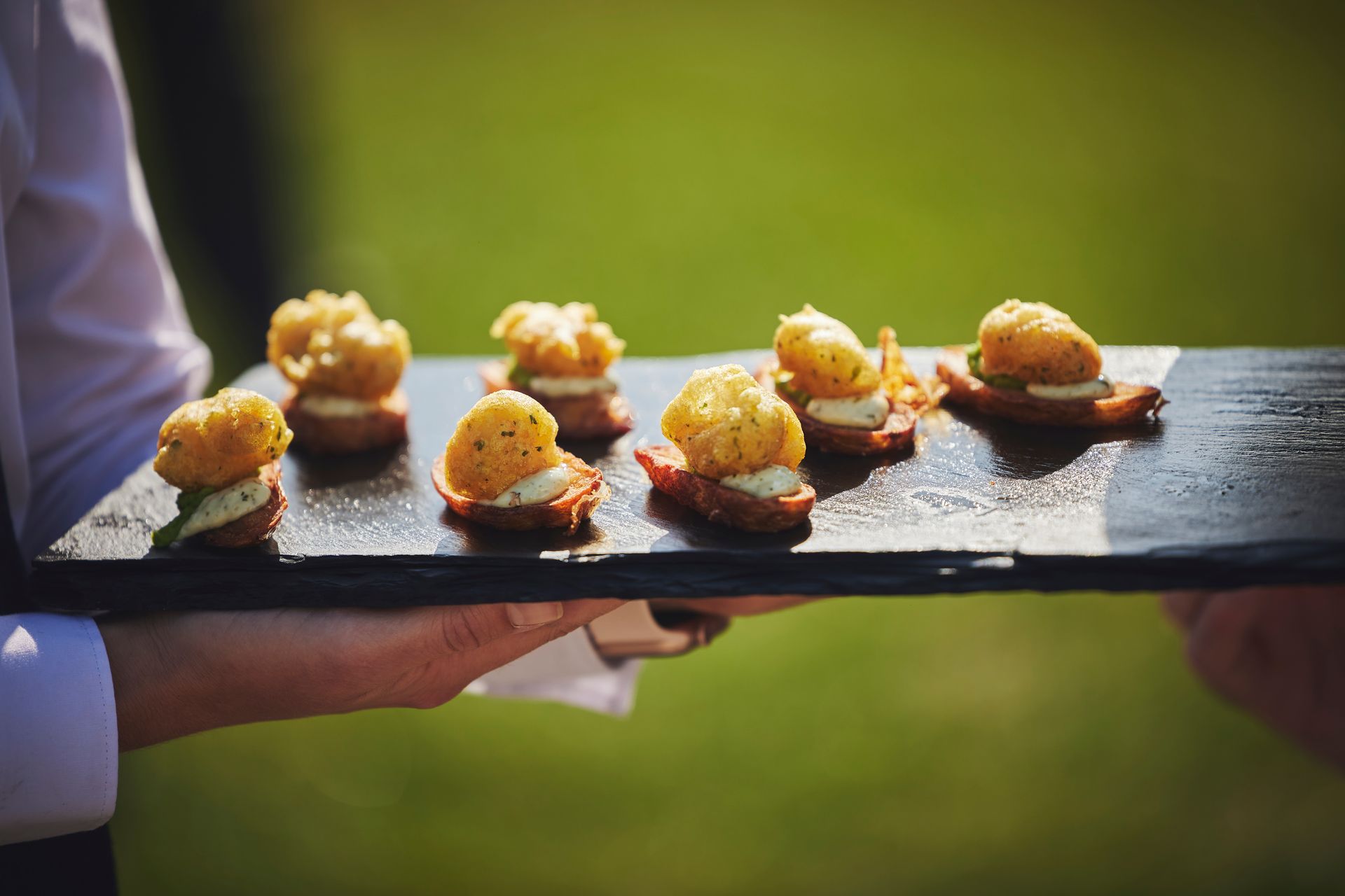 a person is holding a tray of food in their hand .