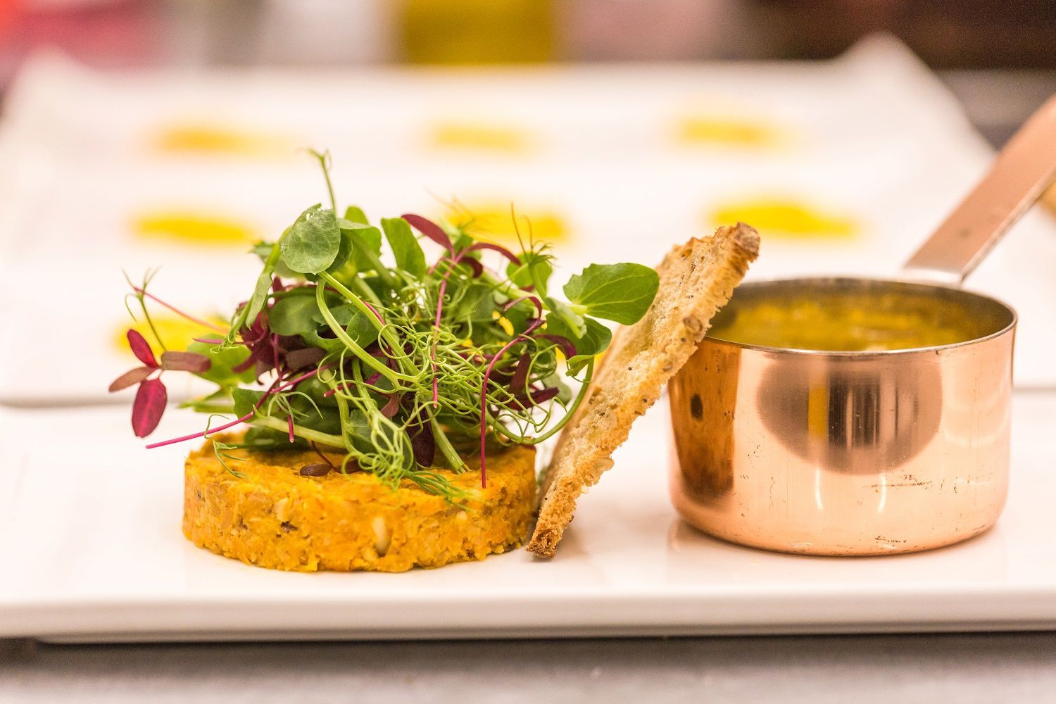 a close up of a plate of food on a table with a copper pot .