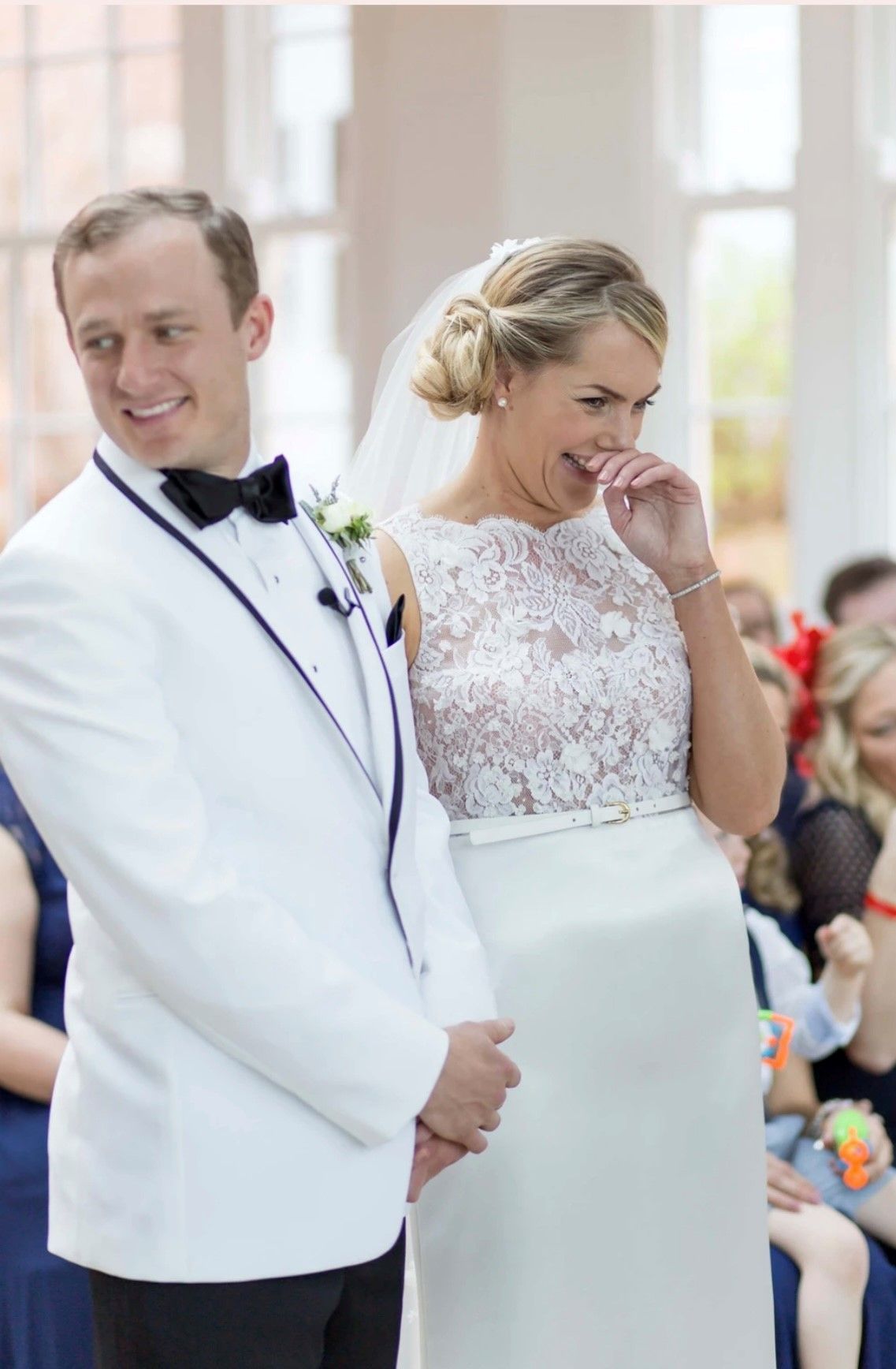 a bride and groom are laughing during their wedding ceremony .
