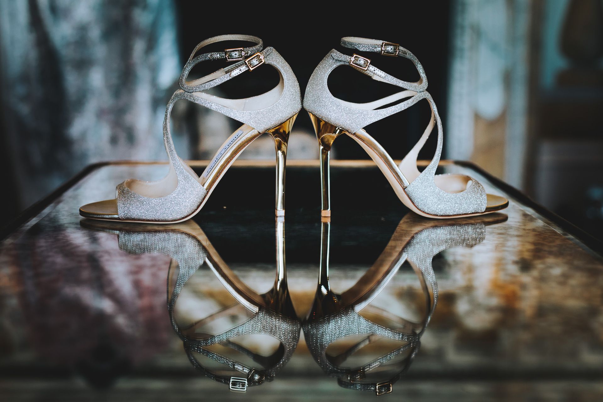 a pair of wedding shoes are sitting on top of a glass table .