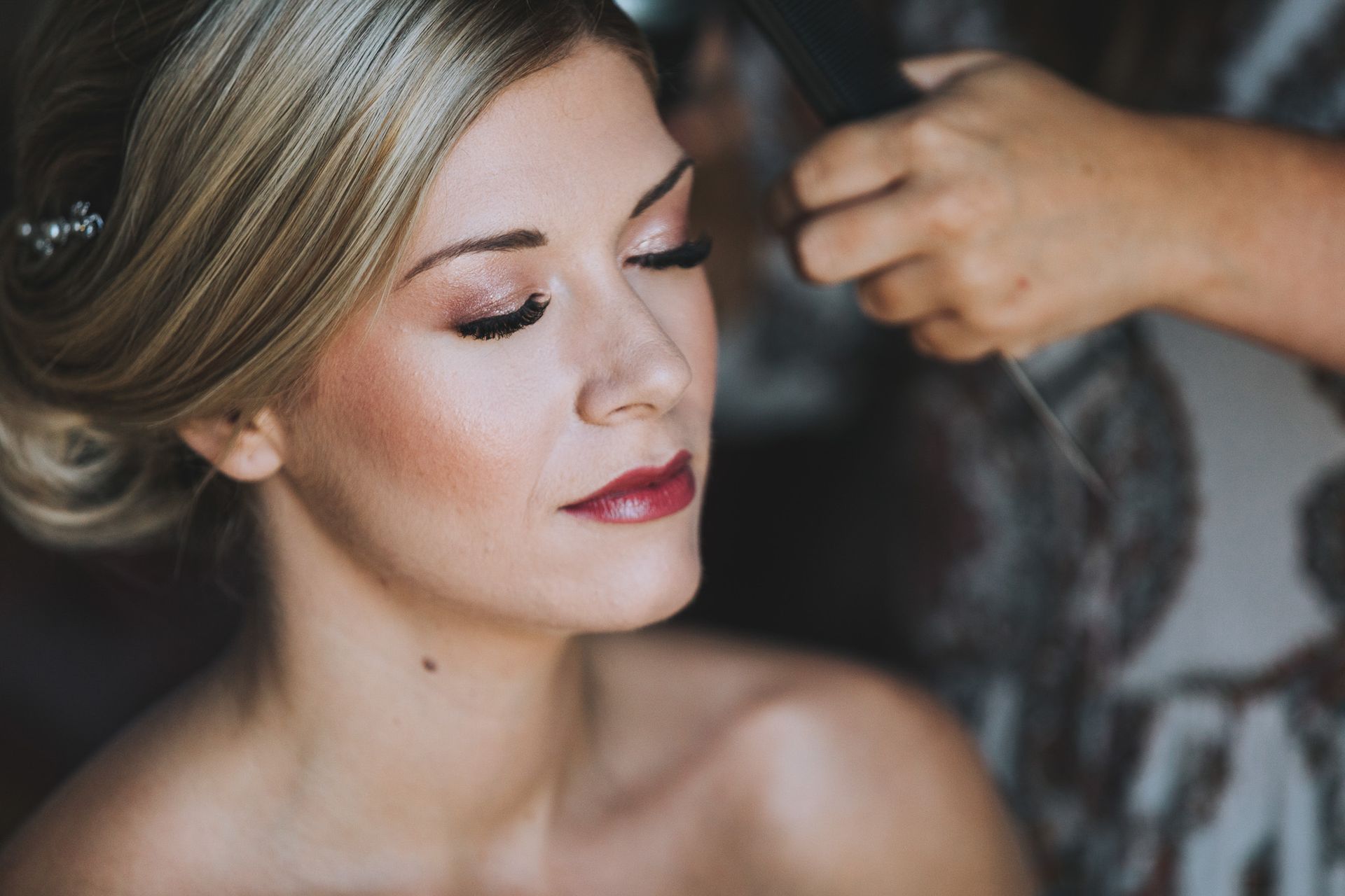 a woman is getting her hair done by a makeup artist .